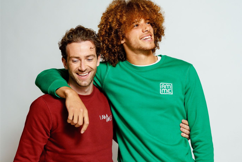 Two men wearing I Am Me sweatshirts